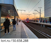 Пассажиры на платформе МЦД "Дмитровская" на закате. Редакционное фото, фотограф Мария Сергеева / Фотобанк Лори