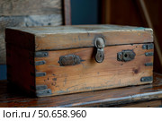 Old wooden box sitting on rustic chair showing signs of wear and tear. Стоковое AI-изображение, AI-художник Иван Рябоконь / Фотобанк Лори