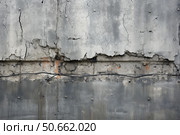 Crumbling concrete wall showing exposed cable and metal fasteners. Стоковое AI-изображение, AI-художник Иван Рябоконь / Фотобанк Лори