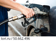 Gas station. A gas station attendant in a car's fuel tank. A man refuels a car with gasoline. Rising fuel prices worldwide. Стоковое фото, фотограф Photojuli / Фотобанк Лори