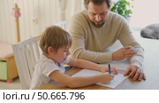 Dad teaches his son writing and counting. Kids primary education. Children learn, study in home school. Daddy male helping teaching little child boy support studying, learning homework. Knowledge day. Стоковое видео, видеограф Марина Демидюк / Фотобанк Лори