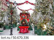 Christmas locomotive on the street of Moscow. New Year's postcard 2026. Beautiful Christmas background with a train. Concept of preparing decorations and attire for the New Year. Стоковое фото, фотограф Photojuli / Фотобанк Лори