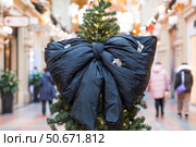 Stylish black bow on the Christmas tree. Beautiful Christmas background. Concept of preparing decorations and furnishings for the New Year. New Year's card 2026. Стоковое фото, фотограф Photojuli / Фотобанк Лори