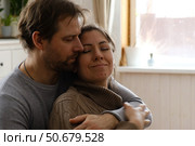 Mature couple hugging hugging each other kissing at home bedroom. Intimate Moment. Tender embrace shared between a loving middle age man and woman, husband and wife. Deep love. Low key, cinematic. Стоковое фото, фотограф Марина Демидюк / Фотобанк Лори