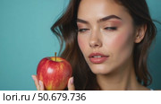 A Woman Poses With a Fresh Red Apple, Looking Directly at the Camera. Стоковое AI-видео, аниматор Sergey Grishin / Фотобанк Лори