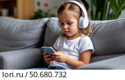 Cute kid girl in watching smartphone. Стоковое AI-изображение, AI-художник Ирина Гильмуллина / Фотобанк Лори