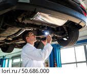 A man is working on a car under a light. Стоковое AI-изображение, AI-художник Ярославский Максим / Фотобанк Лори