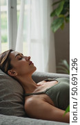 Relaxed calm woman resting breathing fresh air feeling mental balance enjoying wellbeing at home on sofa, satisfied young lady taking pleasure of stress free weekend morning stretching. Стоковое AI-видео, аниматор Sergey Grishin / Фотобанк Лори