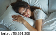 Top view of attractive young woman sleeping well in bed hugging soft white pillow. Teenage girl resting, good night sleep concept. Lady enjoys fresh soft bedding linen and mattress. Стоковое AI-видео, аниматор Sergey Grishin / Фотобанк Лори