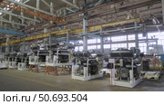 A production hall with various machines and equipment located on a concrete floor, with metal structures and pipes on ceiling and large windows allowing natural light to enter. Стоковое видео, видеограф Дмитрий Нечаев / Фотобанк Лори