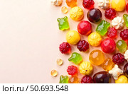 Colorful assorted fruit-shaped jelly and gummy candies scattered on a light pastel background, showcasing a playful and sweet confectionery theme. Стоковое AI-изображение, AI-художник Александра Рублева / Фотобанк Лори