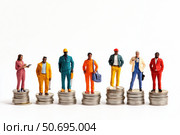 Miniature figures of workers and businessmen on coins reflect the ironic situation: someone is at the top of finance, and someone is barely hanging on - a visual allegory of economic pyramids. Banner. Стоковое AI-изображение, AI-художник Евгений Демидюк / Фотобанк Лори