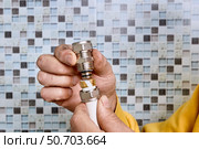 Compression ring is positioned by plumber on pipe section before tightening coupling that joins multilayer pipes in water supply system. Стоковое фото, фотограф Владимир Григорьев / Фотобанк Лори