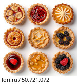 Delicious mini pies variety showing different toppings and crusts on white background. Стоковое AI-изображение, AI-художник Иван Рябоконь / Фотобанк Лори