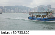 Ferry cruising Victoria harbor. Ship sails across Victoria Harbour against the dense Hong Kong skyscraper background. Slow motion footage. Asia travel destination. Редакционное видео, видеограф Ирина Михайличенко / Фотобанк Лори