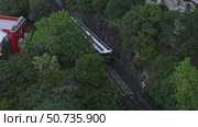 Top view of the famous green tram on the slope of Victoria Peak in Hong Kong passes, lifting visitors to the observation deck. High quality footage. Стоковое видео, видеограф Ирина Михайличенко / Фотобанк Лори