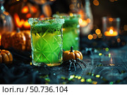 Spooky green halloween cocktails with pumpkins, spiders, and festive lights. Стоковое AI-изображение, AI-художник Иван Рябоконь / Фотобанк Лори