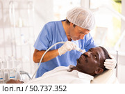 African American undergoing cosmetic facial treatment using ion bubble attachment. Стоковое фото, фотограф Яков Филимонов / Фотобанк Лори