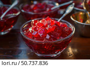 Delicious red jelly cubes glistening in glass bowls, dessert delight. Стоковое AI-изображение, AI-художник Иван Рябоконь / Фотобанк Лори