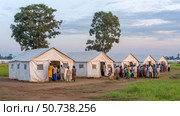 Refugees gathering at makeshift tents in refugee camp. Стоковое AI-изображение, AI-художник Юрий Поздников / Фотобанк Лори