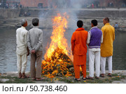 Monks and relatives watching cremation ceremony on bagmati river bank in kathmandu. Стоковое AI-изображение, AI-художник Юрий Поздников / Фотобанк Лори