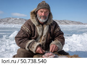 Experienced fisherman preparing freshly caught fish on ice. Стоковое AI-изображение, AI-художник Юрий Поздников / Фотобанк Лори