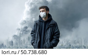Young man wearing protective mask looking at polluted city on fire. Стоковое AI-изображение, AI-художник Юрий Поздников / Фотобанк Лори