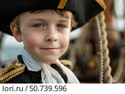 Young captain wearing tricorn hat on ship deck smiling at camera. Стоковое AI-изображение, AI-художник Иван Рябоконь / Фотобанк Лори