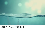 Defocused aqua-mint liquid colored clear water surface texture with splashes bubbles with copy space. Water waves in sunlight background. Стоковое AI-видео, аниматор Sergey Grishin / Фотобанк Лори