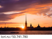 Силуэт Петропавловской крепости в Санкт-Петербурге на фоне заката. Вид на историческую архитектуру у Невы в вечернее время, с яркими красками неба и лучами заходящего солнца. (2018 год). Стоковое фото, фотограф Ольга Визави / Фотобанк Лори