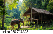 Large elephant standing near a wooden house with a thatched roof in a lush tropical rainforest. Стоковое AI-изображение, AI-художник Михаил Коханчиков / Фотобанк Лори