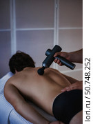 Experience the Soothing Benefits of Gun Percussion Massage Therapy for Relaxation and Relief. Стоковое фото, фотограф Aleksandr Golubev / Фотобанк Лори
