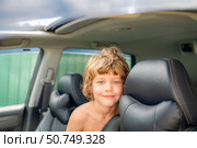 Boy is sitting in a car with his head on the back of the headrest. Стоковое фото, фотограф Дмитрий Брусков / Фотобанк Лори