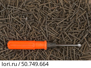 Orange screwdriver lying on the background of screws. Стоковое фото, фотограф Александр Собко / Фотобанк Лори