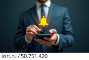 Push-уведомление. Бизнесмен держит смартфон с виртуальным жёлтым звонком. Стоковое AI-изображение, AI-художник Илья Старков / Фотобанк Лори