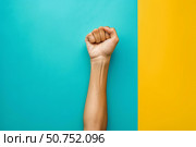 Hand showing fist on colorful background symbolizing power and strength. Стоковое AI-изображение, AI-художник Иван Рябоконь / Фотобанк Лори