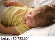 Peaceful adorable baby sleeping on a bed at home. Slumbering little child. Two years old girl sleeps peaceful at domestic room interior background. Serene dream. Cute face close up. Deep kid slumber. Стоковое фото, фотограф Марина Демидюк / Фотобанк Лори