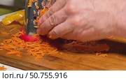 A person is cutting up carrots on a wooden cutting board. Стоковое видео, видеограф Ярославский Максим / Фотобанк Лори