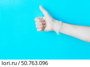 Human hand in transparent vinyl glove above bright blue background. Safety and selfcare concept. Стоковое фото, фотограф Акимова Надежда / Фотобанк Лори