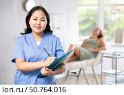 Asian professional cosmetologist advertising facial procedure to patients. Стоковое фото, фотограф Яков Филимонов / Фотобанк Лори
