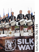 ANGARSK, IRKUTSK REGION, RUSSIA - July 13, 2025: XV International Silk Way Rally, racing competition. Group of beautiful drummers girls perform on open stage before start of motor rally on rainy summer day. Редакционное фото, фотограф Виктория Катьянова / Фотобанк Лори