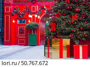Fabulous Christmas background. Festive toys and gift boxes on the New Year tree in Moscow. The concept of decorations for the holiday. New Year's card 2026. Стоковое фото, фотограф Photojuli / Фотобанк Лори