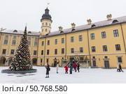 Visitors are near the Christmas tree in the inner courtyard of Nesvizh Castle (2024 год). Редакционное фото, фотограф EugeneSergeev / Фотобанк Лори