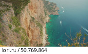 Steep cliffs and turquoise sea waters in Capri Island on a clear summer day. Стоковое видео, видеограф Ольга Сухарева / Фотобанк Лори