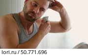 Man shaving his face. Man shaving beard with trimmer. Young Handsome man sitting in front of the mirror. Bearded 30s male cutting trimming mustache using electric shaver in bathroom. Morning routine. Стоковое видео, видеограф Марина Демидюк / Фотобанк Лори