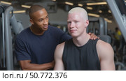 Personal trainer supporting albino athlete during workout. Стоковое AI-видео, аниматор Юрий Поздников / Фотобанк Лори