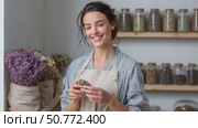 Herbalist holding dried herbs, smiling at camera. Стоковое AI-видео, аниматор Юрий Поздников / Фотобанк Лори