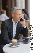 Businessman talking on phone at outdoor cafe. Стоковое AI-видео, аниматор Юрий Поздников / Фотобанк Лори