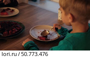 Children Eating Birthday Cake Slice on a Birthday Party at Home. Siblings, girls and a boy together celebrating a party, eating cake sitting at festive table. Little Kid Celebration. Surprise. Low key. Стоковое видео, видеограф Марина Демидюк / Фотобанк Лори