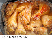 Oven-baked chicken drumsticks removed from roasting bag, showcasing juicy golden-brown results. Стоковое фото, фотограф Татьяна Степанищева / Фотобанк Лори